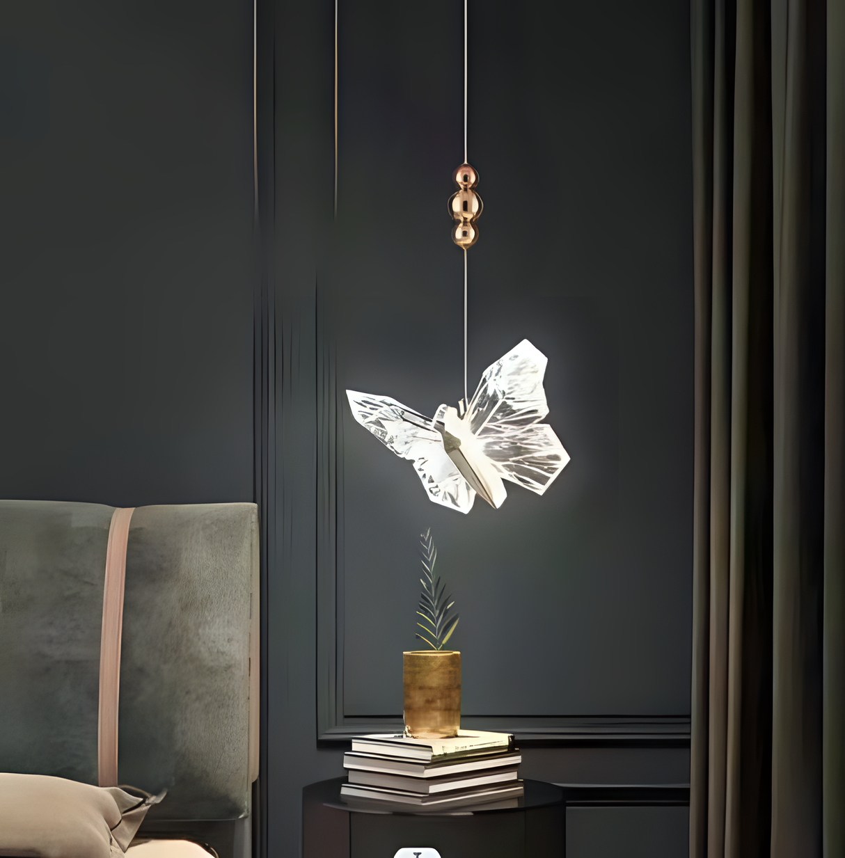 A stunning butterfly-shaped pendant light with a transparent, illuminated design hangs beside a bed, creating an elegant and artistic bedside lighting fixture.