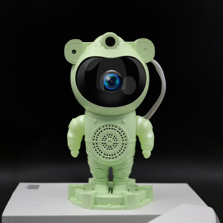 Green robot toy with a black screen on a white platform against a black background