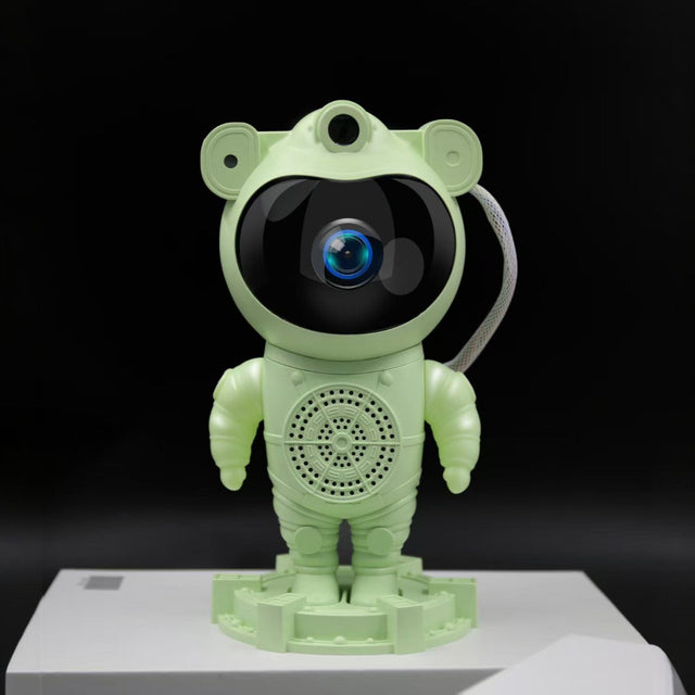 Green robot toy with a black screen on a white platform against a black background