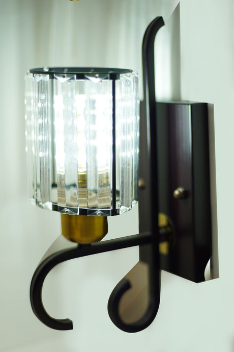 A modern wall light with transparent crystal rods, a gold base, and LED bulbs for a bright yet elegant glow.