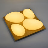 A square ceiling fixture with four rounded triangular lights arranged in a clover shape, 