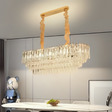 A luxurious crystal chandelier hanging above a dining table with wooden and metal accents.