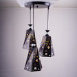A cluster of three black and gold angular pendant lights with intricate patterns, suspended from a single ceiling mount.
