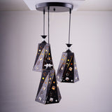 A cluster of three black and gold angular pendant lights with intricate patterns, suspended from a single ceiling mount.
