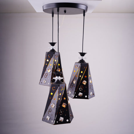 A cluster of three black and gold angular pendant lights with intricate patterns, suspended from a single ceiling mount.
