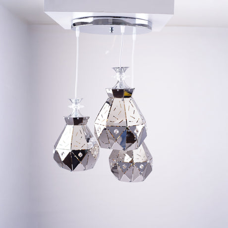 Three crystal-like teardrop pendant lights hanging from a chrome ceiling mount.