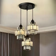A modern chandelier with three black metal and glass pendant lights hanging from a black circular ceiling mount.
