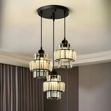 A modern chandelier with three black metal and glass pendant lights hanging from a black circular ceiling mount.
