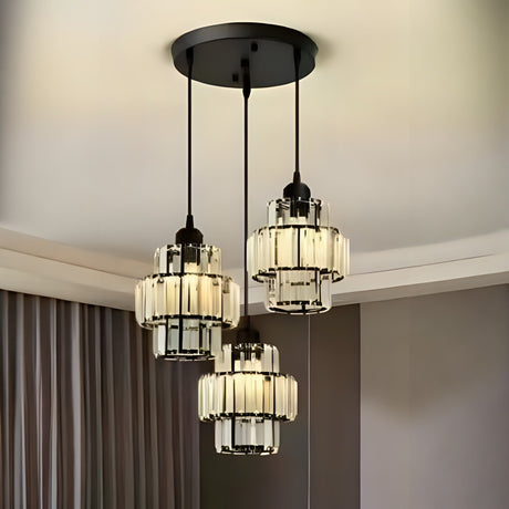 A modern chandelier with three black metal and glass pendant lights hanging from a black circular ceiling mount.
