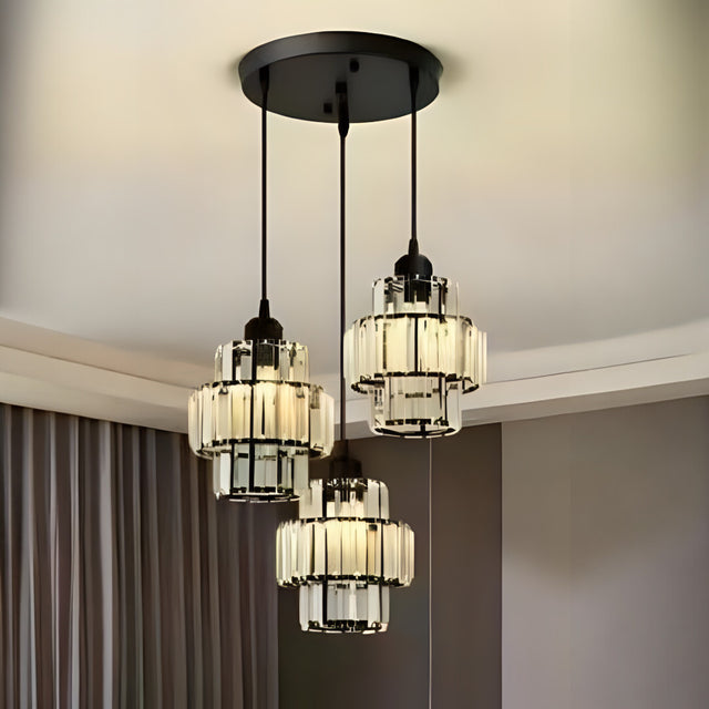A modern chandelier with three black metal and glass pendant lights hanging from a black circular ceiling mount.
