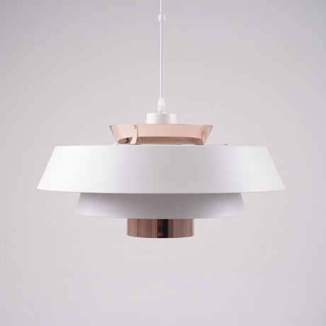 A modern layered pendant light with a matte white and copper finish, featuring a wide circular design with concentric discs, hanging from a black cord against a light gray background.