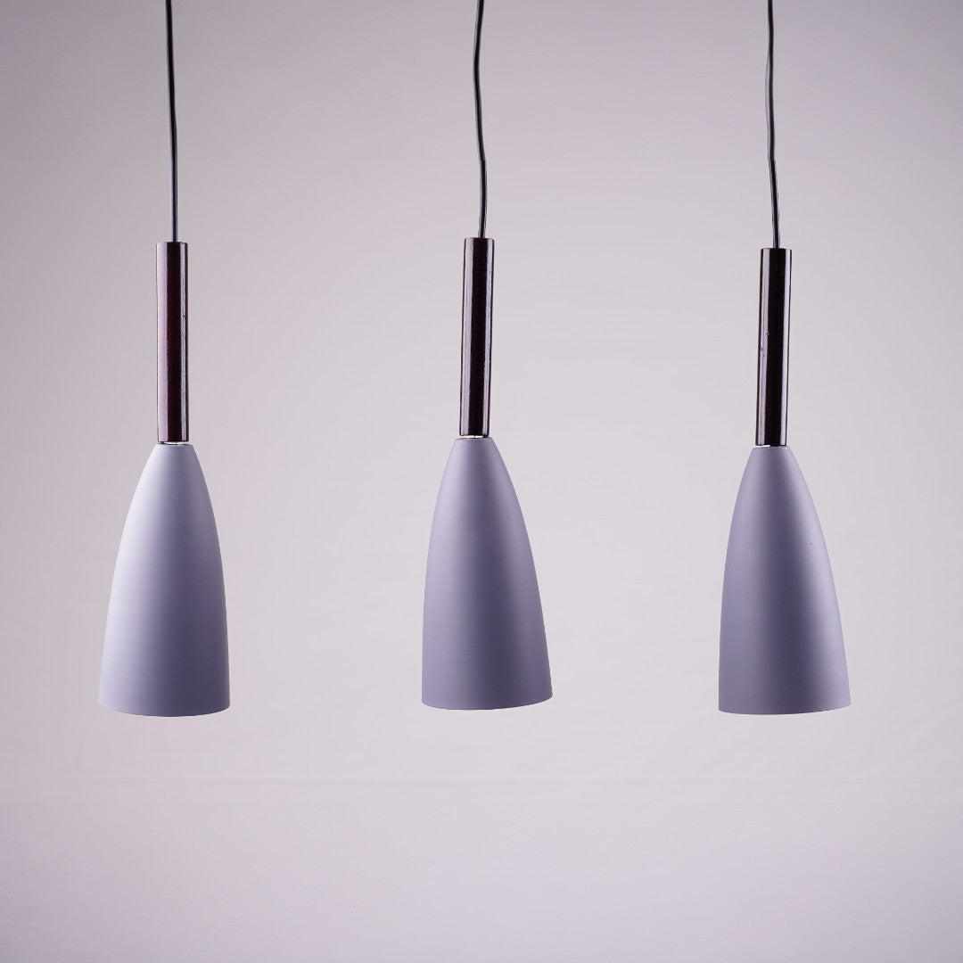 A set of three modern cone-shaped pendant lights with white shades and wooden accents, hanging in a row.
