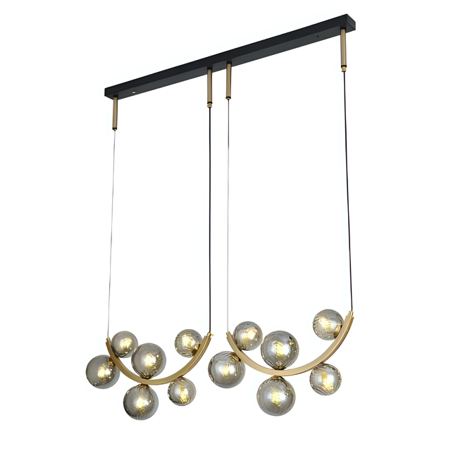 A contemporary gold chandelier with two curved metal arms, each holding multiple spherical grey glass globe lights, suspended from a black rectangular ceiling mount.
