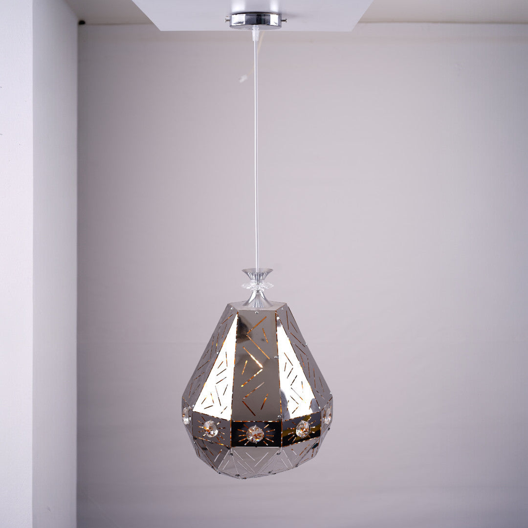 A geometric, faceted metal pendant light with reflective surfaces and decorative patterns, hanging from the ceiling.