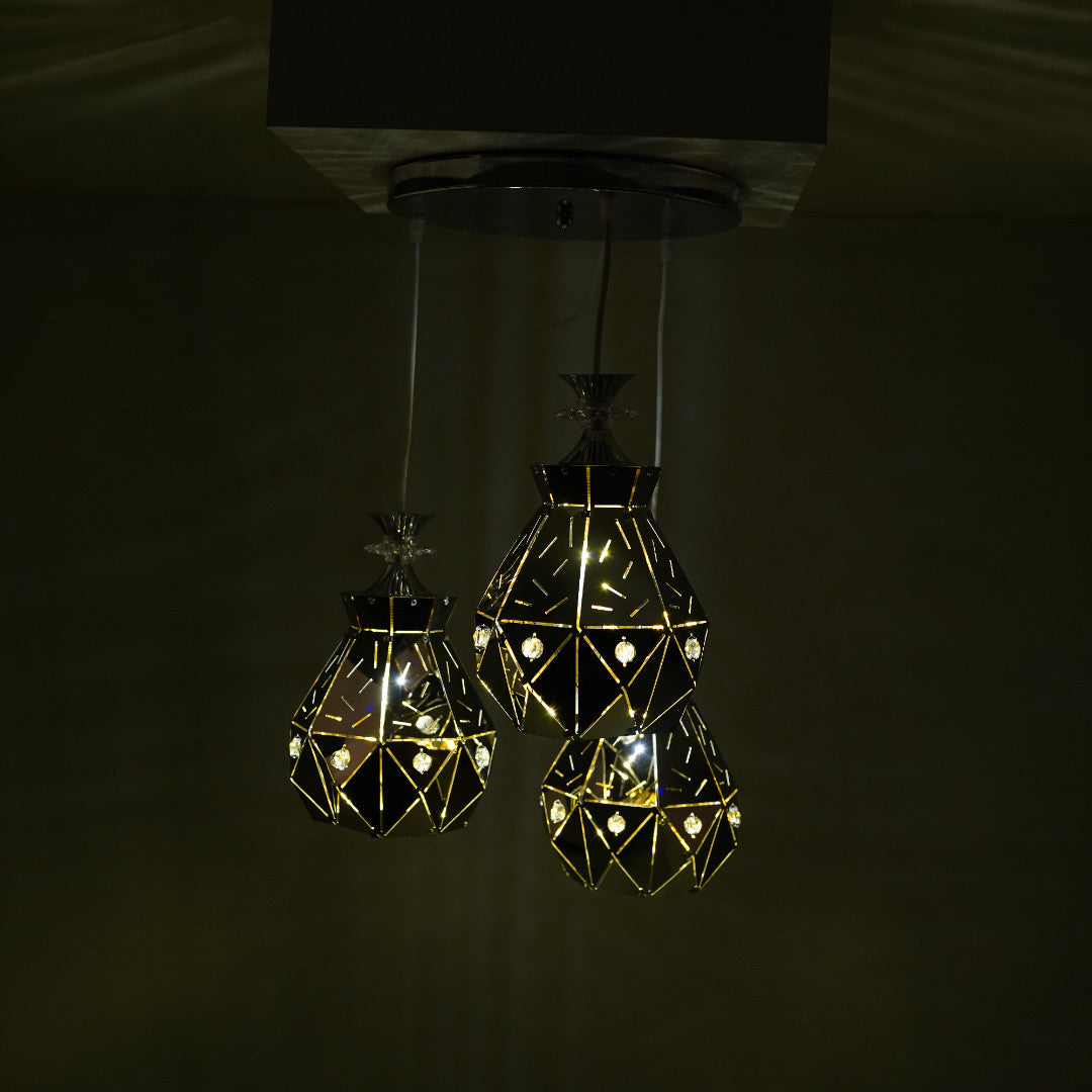 three crystal-like pendant lights glowing in the dark, creating a warm, geometric illumination.