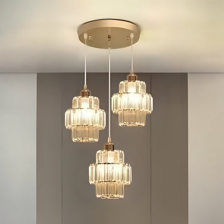 A three-light pendant chandelier with gold and glass accents, suspended from a gold ceiling mount.