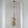 A cascading pendant light with multiple grey glass spheres suspended at varying heights, creating an elegant and artistic look.