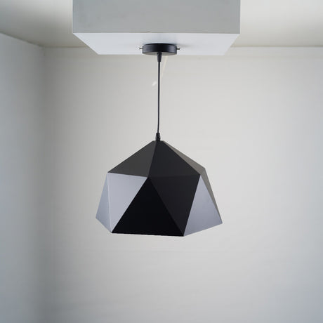 A geometric black pendant light with a faceted, polygonal design is suspended from a white ceiling. The fixture is fixed directly to a square ceiling mount.
