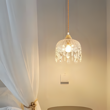 A vintage-style crystal pendant light with delicate hanging beads, emitting a warm glow.