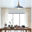 A grey and gold pendant light with a wide, curved shade, elegantly complementing the dining space.
