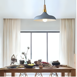 A grey and gold pendant light with a wide, curved shade, elegantly complementing the dining space.
