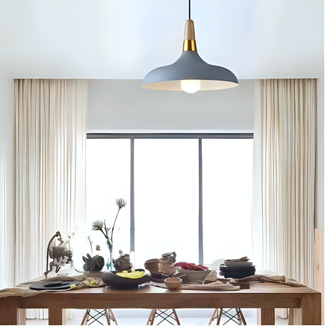 A grey and gold pendant light with a wide, curved shade, elegantly complementing the dining space.

