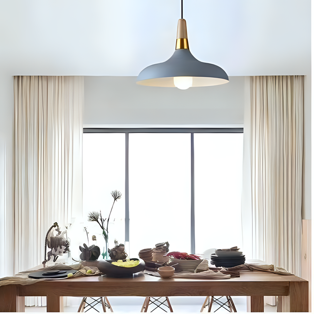 A grey and gold pendant light with a wide, curved shade, elegantly complementing the dining space.
