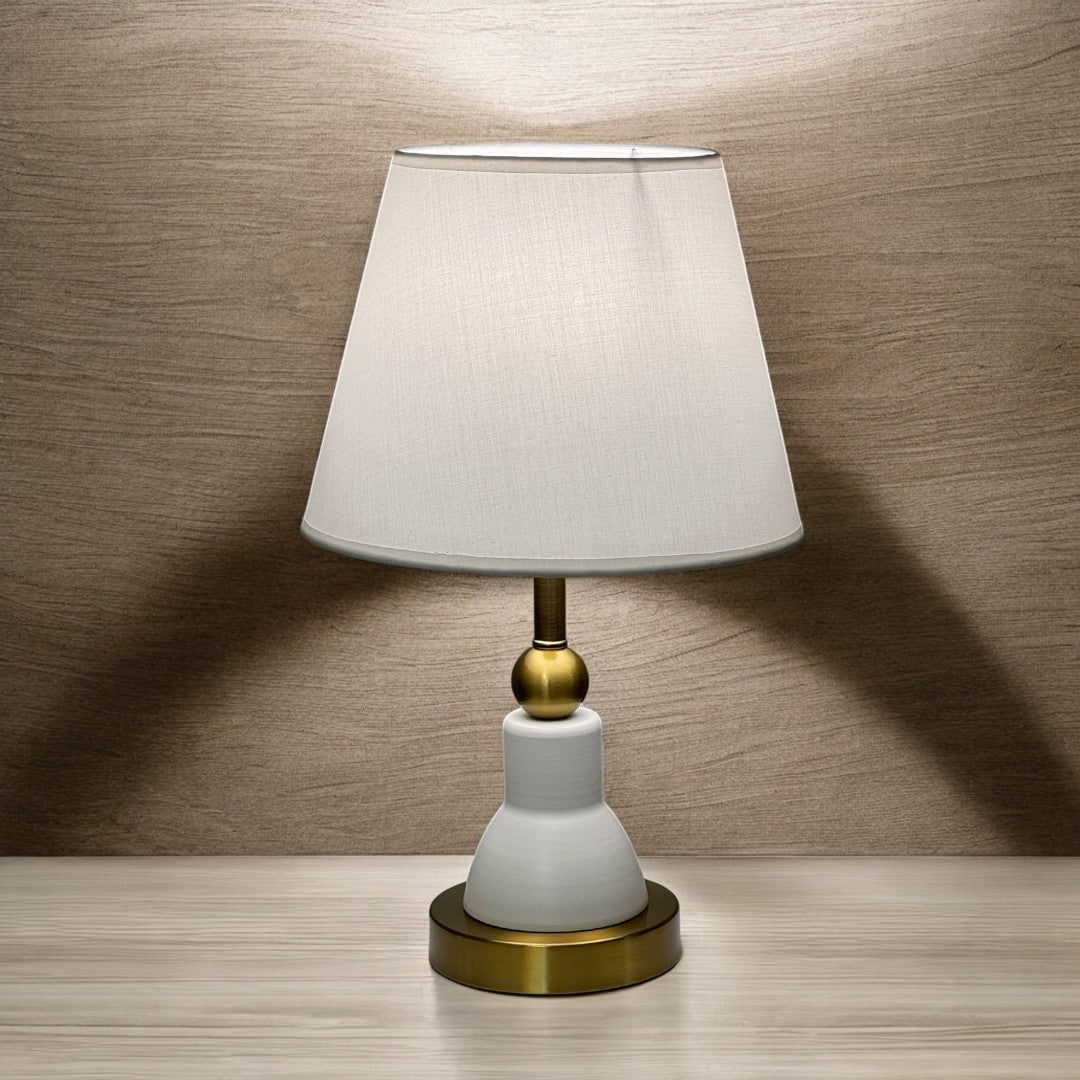 Classic white and gold table lamp with a bottle-shaped metal base and a white fabric shade.
