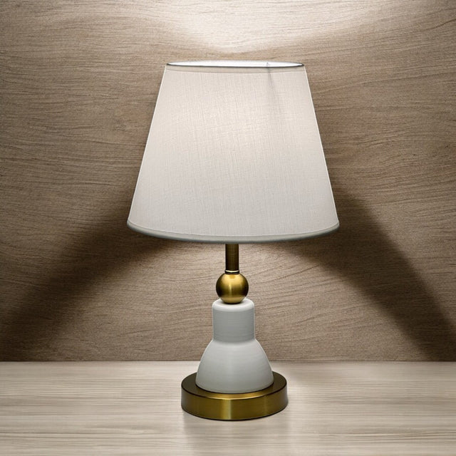 Classic white and gold table lamp with a bottle-shaped metal base and a white fabric shade.

