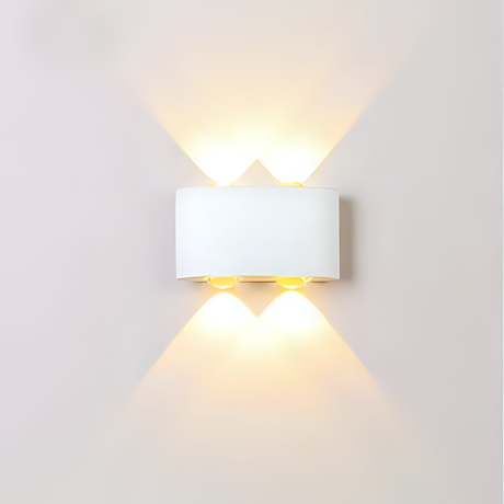 A sleek white wall light with a rectangular shade, casting an elegant upward and downward glow against a plain white wall.
