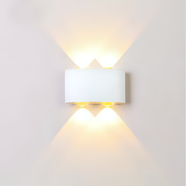 A sleek white wall light with a rectangular shade, casting an elegant upward and downward glow against a plain white wall.