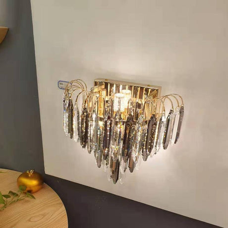 A statement wall fixture featuring hanging crystal strands and a reflective metal base, equipped with 2 led lamp E27 Creating a dazzling and opulent lighting effec