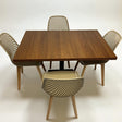 Wooden dining table with four chairs on a white background
